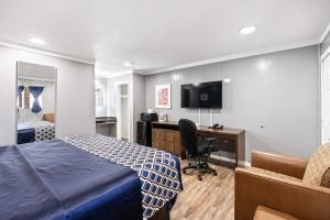 a hotel room with a bed and a desk and a television at Western Inn by Capital O Cleburne TX in Cleburne