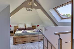 a bedroom with a bed in a attic at Villa Argonne - Cottages & Spa Privatif in Ouville-la-Rivière +60 photos