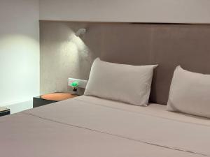 a bed with white sheets and pillows in a room at Ace Lagoon View Airport Hotel in Katunayaka