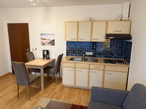a kitchen with a table and chairs and a kitchen with a sink at Strandmuschel in Norddeich