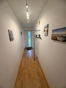 a hallway with paintings on the walls of a room at Strandmuschel in Norddeich