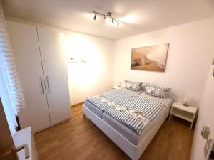 a small bedroom with a bed and a cabinet at Strandmuschel in Norddeich