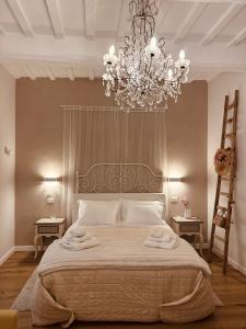 a bedroom with a large bed with a chandelier at Armonia - Casa Vacanze in Spello