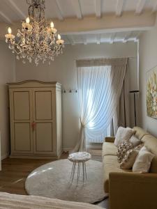 a living room with a couch and a chandelier at Armonia - Casa Vacanze in Spello