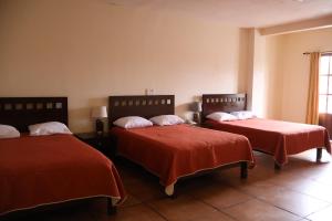 a room with two beds with red sheets and a window at Hotel El Cafetalero in Xicotepec de Juárez +49 photos