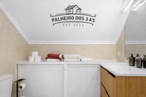 a bathroom with a sink and a house on the wall at Palheiro dos 3 A`s in Achadas da Cruz +29 photos