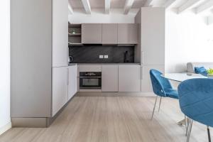a kitchen with white cabinets and a table and chairs at Apartment-Boutique Stella in Cittadella