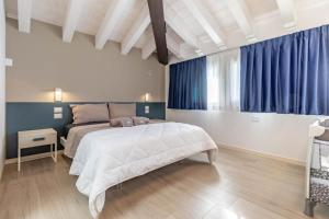 a bedroom with a large bed and blue curtains at Apartment-Boutique Stella in Cittadella