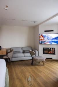 un salon avec un canapé et une télévision dans l'établissement Pine Hotel & Spa Brezovice, à Brezovicë
