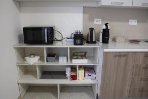 a microwave on a shelf in a kitchen at Al Giardino b&b in Acri