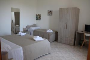 a room with two beds and a desk and a television at Al Giardino b&b in Acri