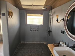 a bathroom with a sink and a mirror at Kampasi Olmoingo Camp in Talek