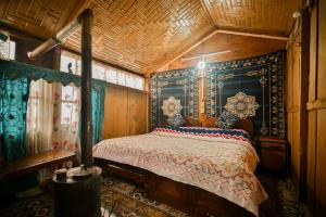 a bedroom with a bed in a room with a wooden ceiling at Dolphin houseboat in Srinagar