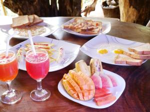 a table with plates of food and two glasses of juice at White Amora Ella in Ella