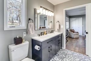a bathroom with a sink and a toilet and a mirror at Waterfront Deck, Shell Knob Gem on Table Rock! in Shell Knob +24 photos