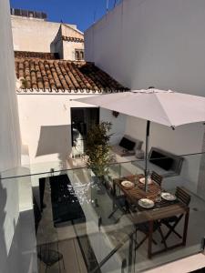 a patio with a table and an umbrella on a building at Unique Townhouse with rooftop pool in Estepona