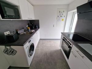 a kitchen with a sink and a washing machine at EderseeGlück - Fewo 3 ebenerdig klimatisiert in Edertal