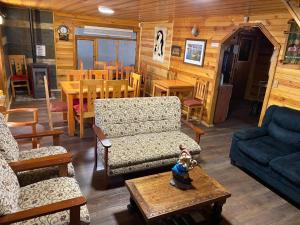 a living room with a couch and chairs and a table at Chiloe Seta in Ancud +1 photo
