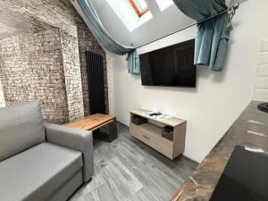 a living room with a couch and a flat screen tv at Apartament Hexagon nr 36 in Grzybowo +19 photos