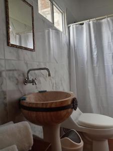 a bathroom with a wooden sink and a toilet at Casa GALLARDO in Danlí