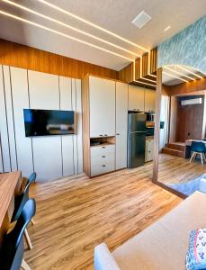 a living room with white cabinets and a kitchen at Studio Moderno e Completo in Aracaju