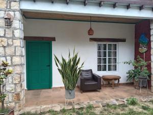 a green door and a chair on a patio at Casa GALLARDO in Danlí +5 photos