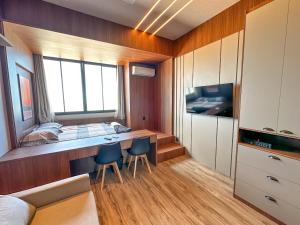 a bedroom with a bed and a desk with two chairs at Studio Moderno e Completo in Aracaju