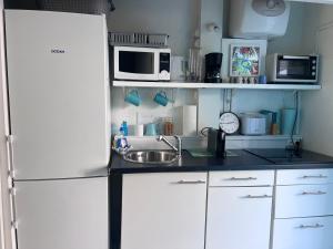 a kitchen with a white refrigerator and a sink at Sunset View & Ocean Breeze in Cul de Sac