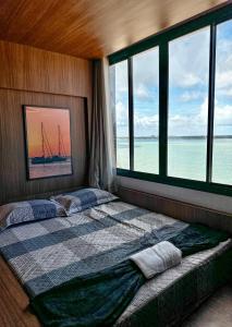 a bedroom with a bed with a view of the ocean at Studio Moderno e Completo in Aracaju
