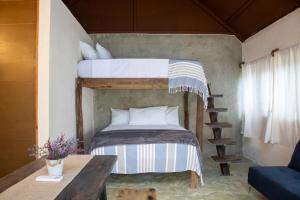 ein Schlafzimmer mit einem Etagenbett und einem Tisch in der Unterkunft Cabañas Tzikin, Telchac Puerto in Telchac + 40 Fotos