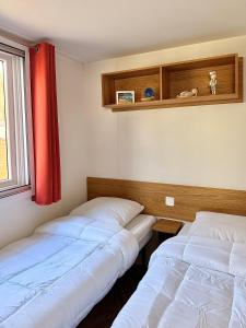 two beds in a room with a red curtain at Eden Cottages - Premium Cottage avec Piscine in Antibes +6 photos
