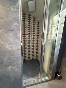 a shower with a glass door in a bathroom at Apartament Hexagon nr 36 in Grzybowo