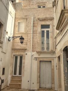 a stone building with a door and a balcony at Liuzzi ross in Martina Franca