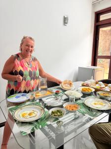 an older woman sitting at a table with plates of food at Sonora in Kandy +36 photos