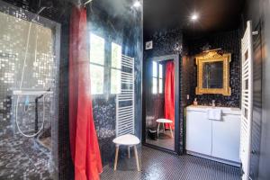 a bathroom with a shower and a red shower curtain at Echappée royale in Saint-Benoît-la-Forêt