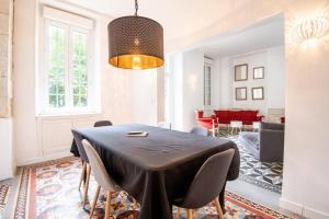 a dining room with a black table and chairs at Echappée royale in Saint-Benoît-la-Forêt