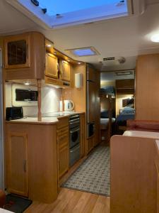 a kitchen in an rv with wooden cabinets at Hagen Camping Mini hus in Kjerrvika