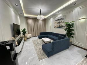 a living room with a blue couch and a table at Super Luxury Private Complex Apt In New Cairo in New cairo
