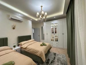 a bedroom with two beds and a chandelier at Super Luxury Private Complex Apt In New Cairo in New cairo