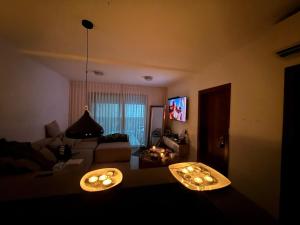 a living room with a couch and a tv at Boutique in Rothschild in Rishon LeẔiyyon