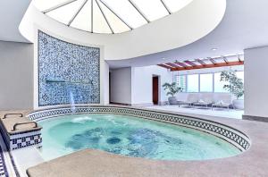 a large swimming pool in a house with a skylight at Hotel Cassino Tower Campinas Cambuí By Nacional Inn in Campinas