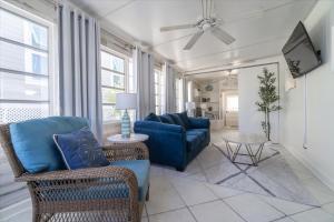 a living room with a blue couch and a tv at Cozy Conch Cottage in Cudjoe Key