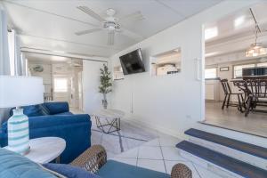 a living room with a blue couch and a table at Cozy Conch Cottage in Cudjoe Key