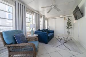 a living room with a blue couch and a tv at Cozy Conch Cottage in Cudjoe Key +33 photos