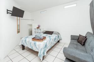 a bedroom with a bed and a couch at Departamento Palmito in La Paz