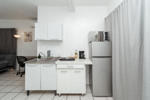 a kitchen with white cabinets and a white refrigerator at Departamento Palmito in La Paz +8 photos