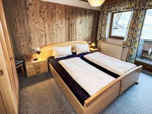 a bedroom with a large bed with a wooden wall at Apartment Untererhof-1 by Interhome in Pankrazberg