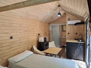 a room with a bed and a table and a kitchen at Bungalows y Glamping Medina Sidonia in Medina Sidonia