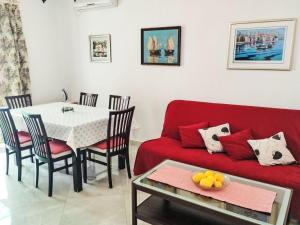 a living room with a red couch and a table at Holiday Home Bernardi by Interhome in Lumbarda