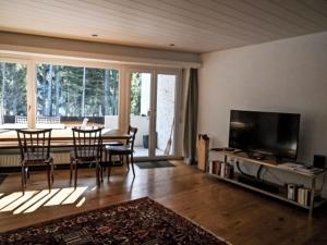 a living room with a table and chairs and a television at Apartment Rustica by Interhome in Lenzerheide